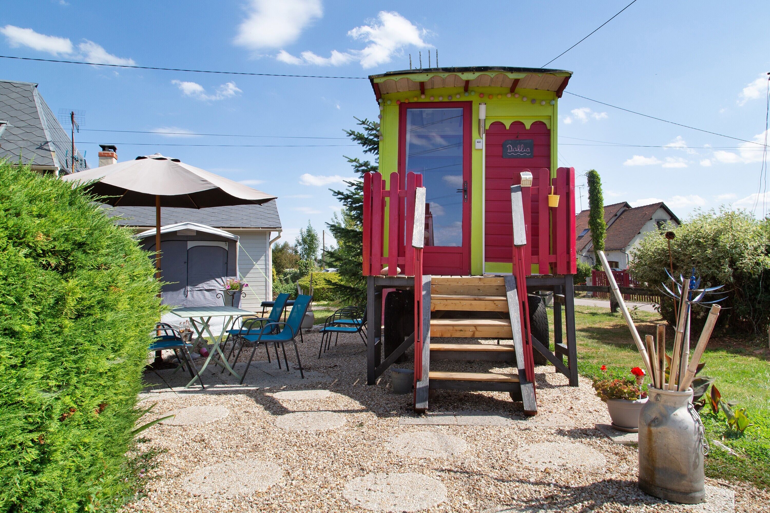 Una casa de juegos colorida con una puerta roja y una pequeña escalera que la lleva.