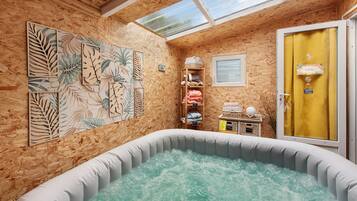 A spa room with a hot tub, wooden walls, and a skylight.