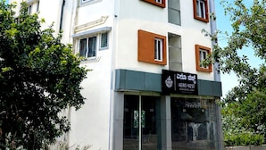 En hotelbygning med flere etager i moderne stil, med en markant indgang og et skilt.