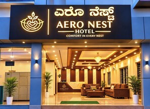 Exterior del hotel Aero Nest, con una zona de recepción y asientos.