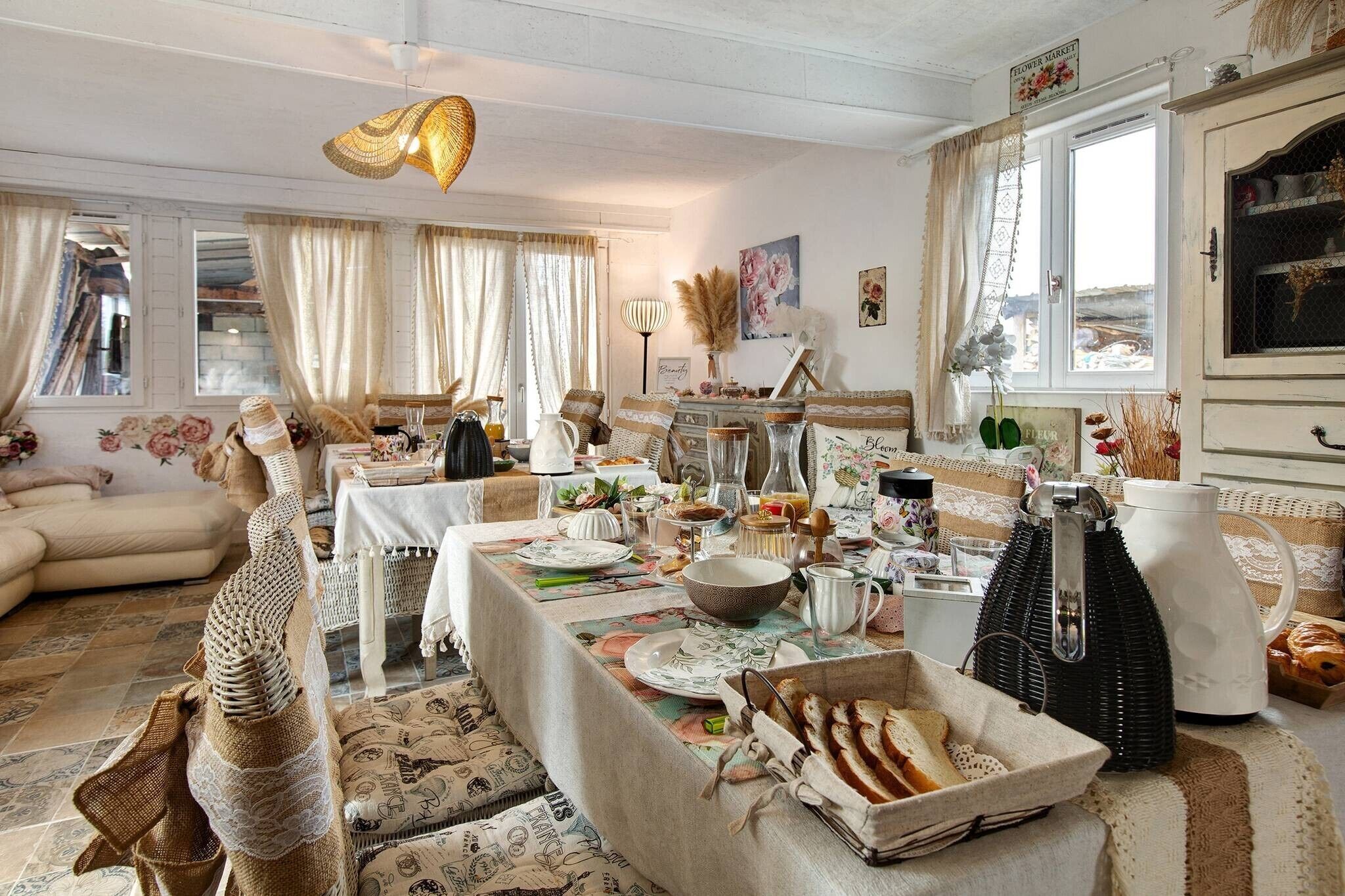 Une pièce chaleureuse et bien éclairée, avec une table à manger dressée pour le repas, entourée de divers ustensiles de cuisine et d’objets de décoration.