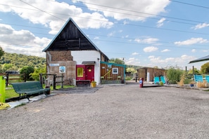 A building with a red door, a sign indicating a spa, and a gravel parking area.