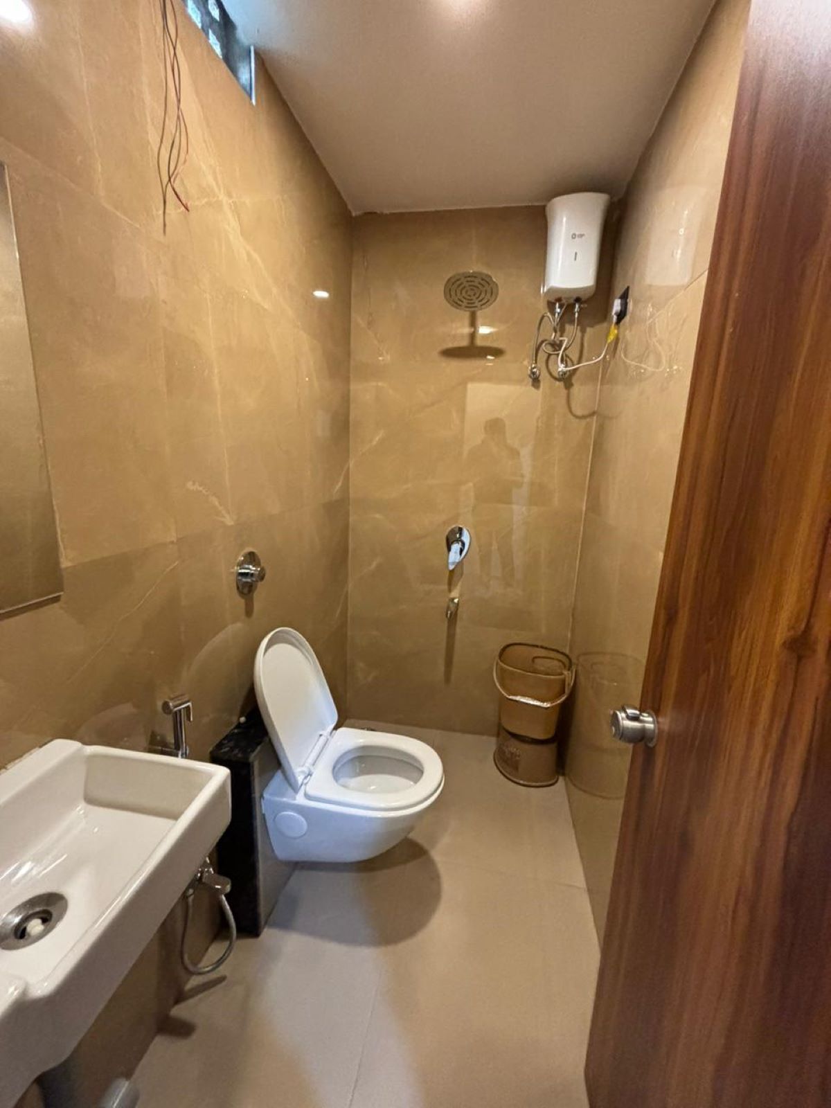 A small bathroom with a toilet, sink, and shower.