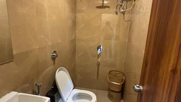 A small bathroom with a toilet, sink, and shower.