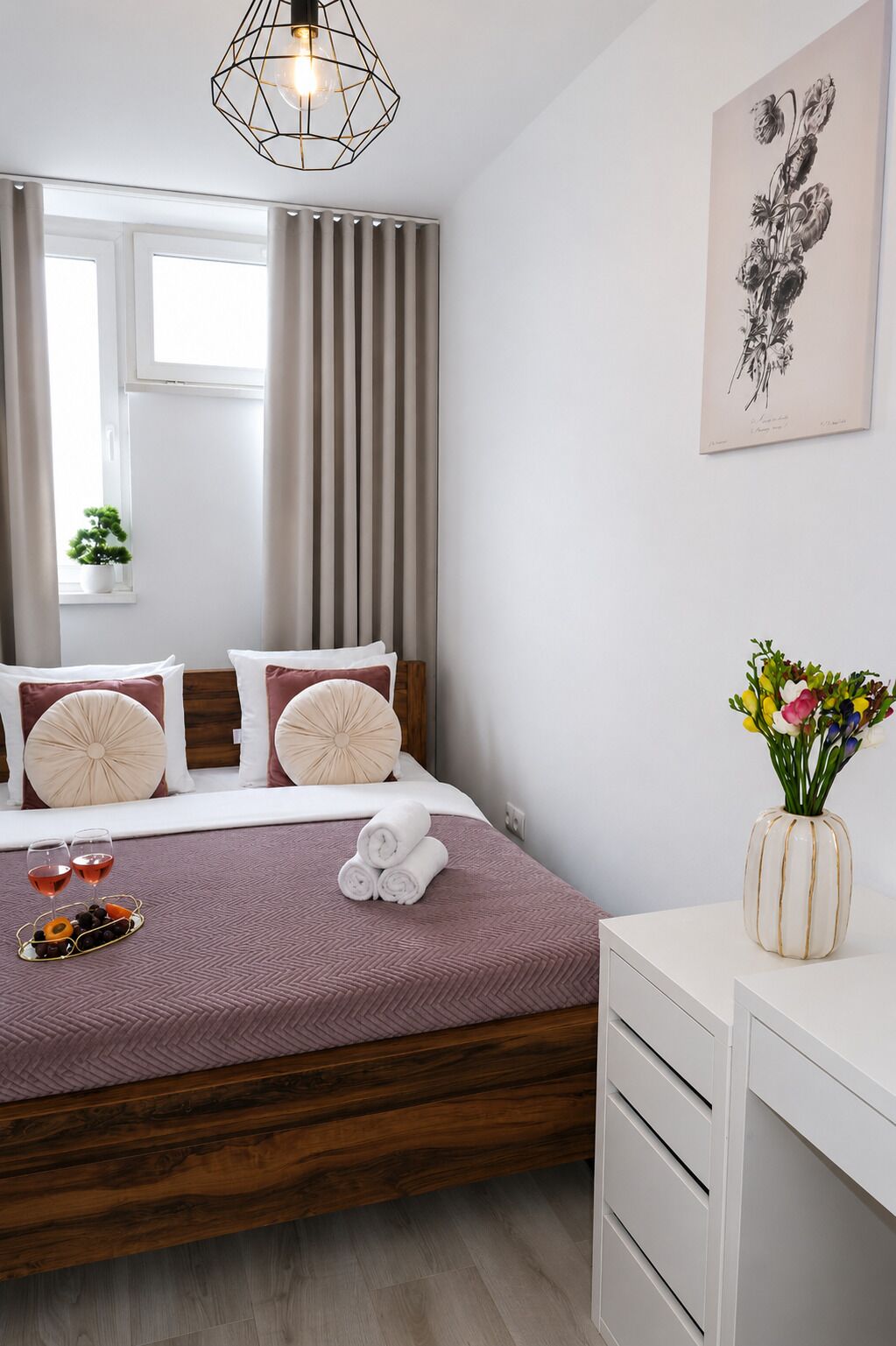A bedroom with a bed, bedside table, and a wall-mounted artwork.