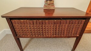 A wooden desk with a built-in bookshelf containing multiple volumes. - Laneside Barn (Hope Valley)