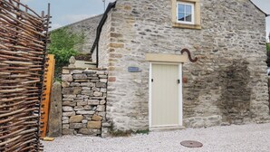 A stone building with a single door and a small window. - Laneside Barn (Hope Valley)