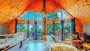 Un intérieur spacieux avec un plafond haut, de grandes fenêtres et un coin salon confortable.