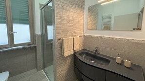 A modern bathroom with a glass shower enclosure, a vanity with a black sink, and a mirror above the sink. - Am'Arena Apartment - Sleeps 4, 300 meters from the Arena (Verona)