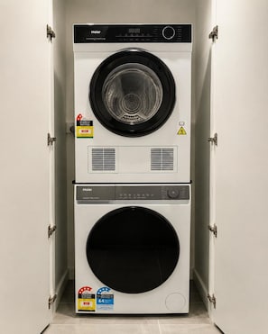 A compact, wall-mounted Haier washer and dryer unit with energy and water efficiency ratings. - Rooftop Infinity Pool! 5 Guests - Free Park & Gym (Fortitude Valley)