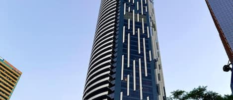 Un gratte-ciel moderne et imposant, doté d’une façade originale caractérisée par des lignes verticales et un design incurvé.