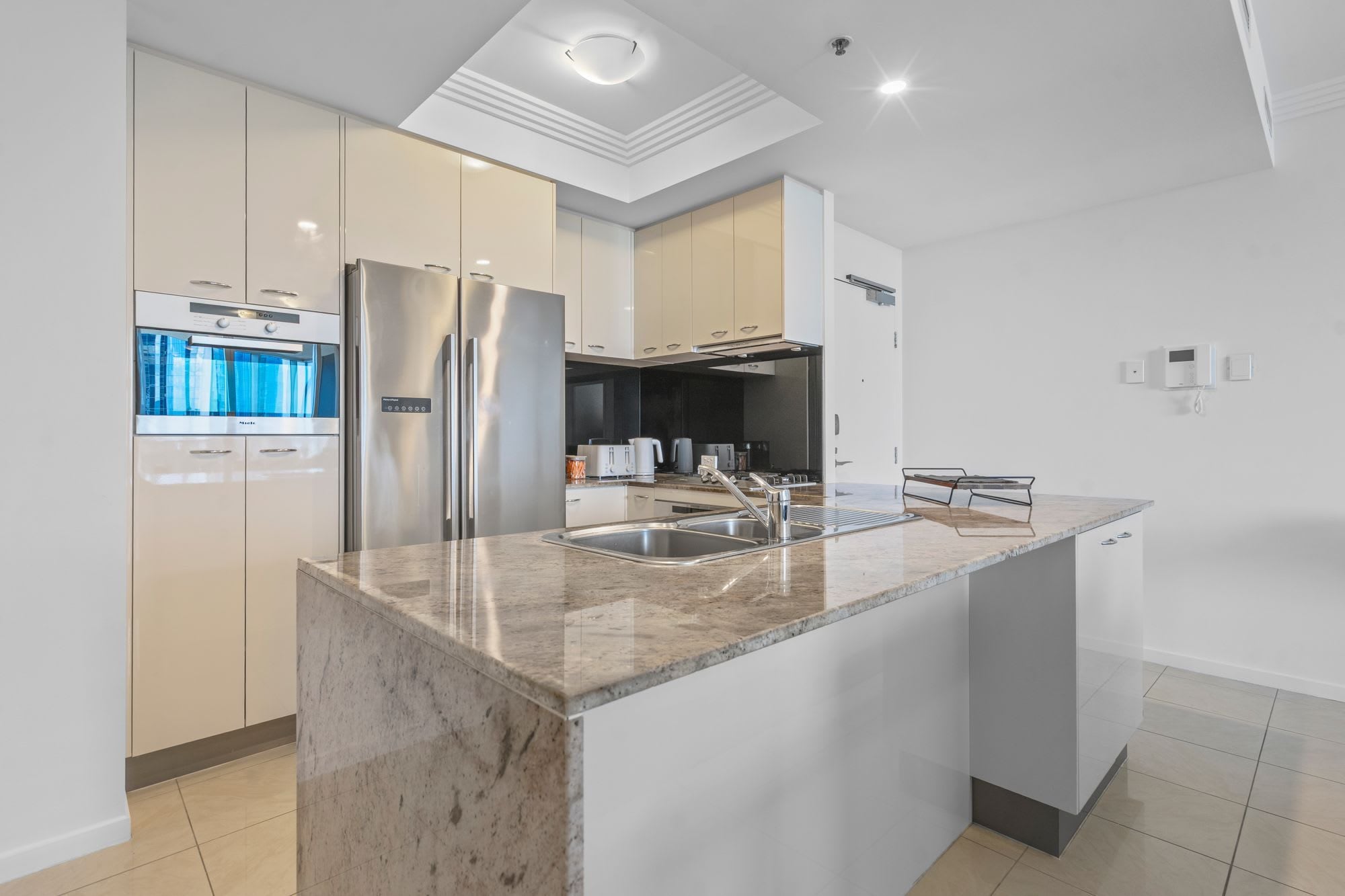 A modern kitchen with a built-in refrigerator, a double sink, and a large countertop.