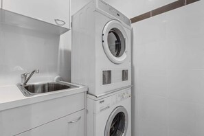 A laundry area with a washing machine and a sink. - City Skyline from Level 37 | Free Parking, Pool & Gym (Brisbane City)