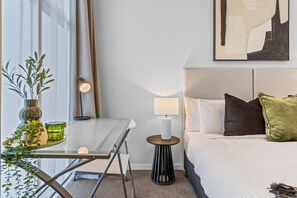 A hotel room with a bed, bedside table, lamp, and a painting on the wall. - City Skyline from Level 37 | Free Parking, Pool & Gym (Brisbane City)