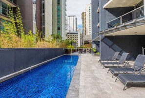 A rooftop swimming pool with lounge chairs and a view of surrounding buildings. - City Skyline from Level 37 | Free Parking, Pool & Gym (Brisbane City)