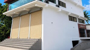 Un hotel de varios pisos con un diseño arquitectónico moderno, que destaca una sección roja en el lado izquierdo y un frente de vidrio en los pisos superiores.