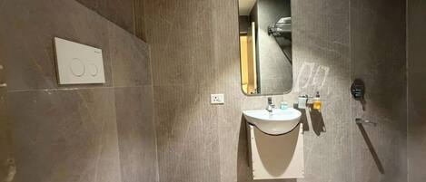 A modern bathroom with a toilet, sink, and shower.