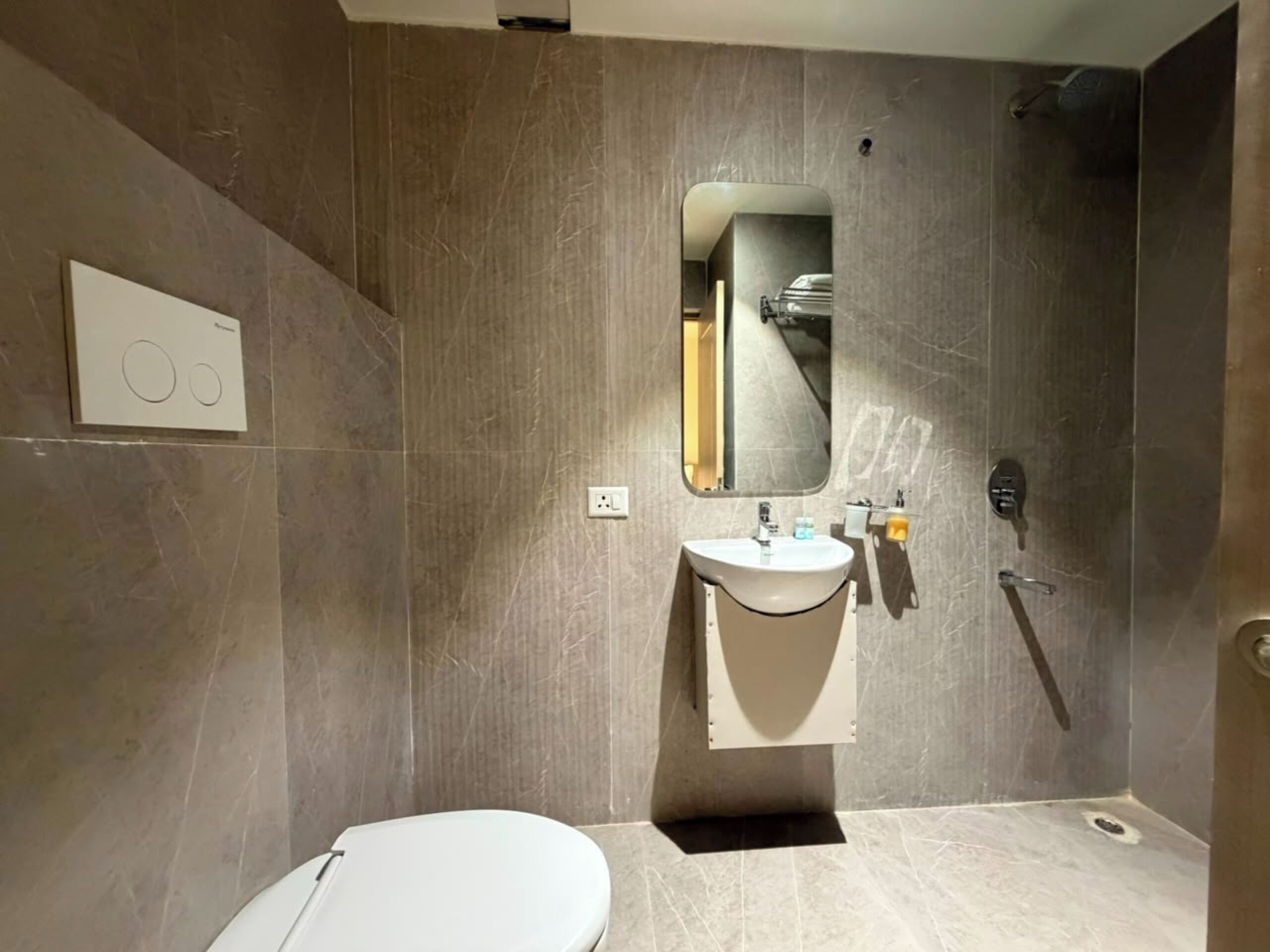 A modern bathroom with a toilet, sink, and shower.