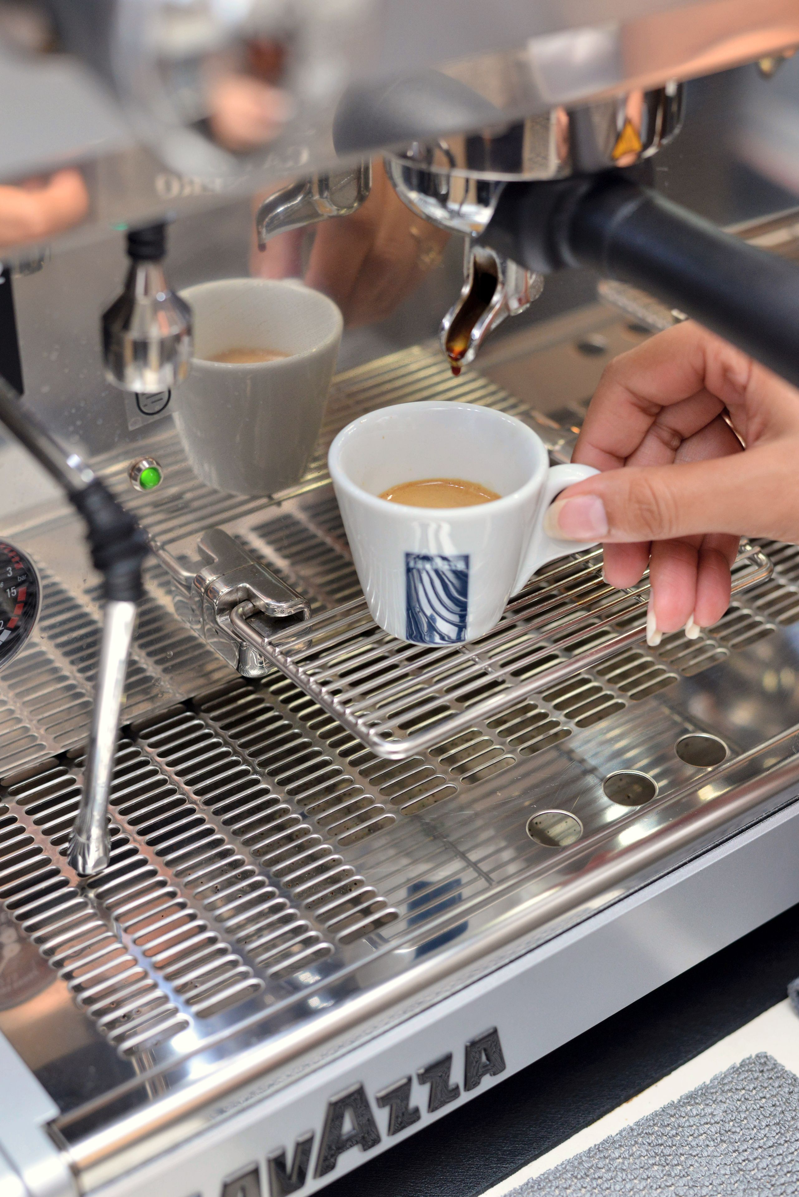 A coffee machine with a portafilter and a cup of coffee being prepared.