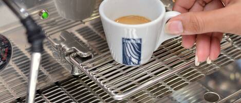 A coffee machine with a portafilter and a cup of coffee being prepared.
