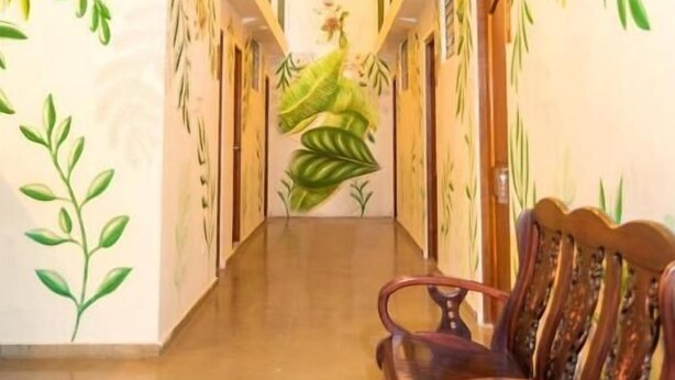 Un pasillo con un banco, una escalera y un mural de un ave.