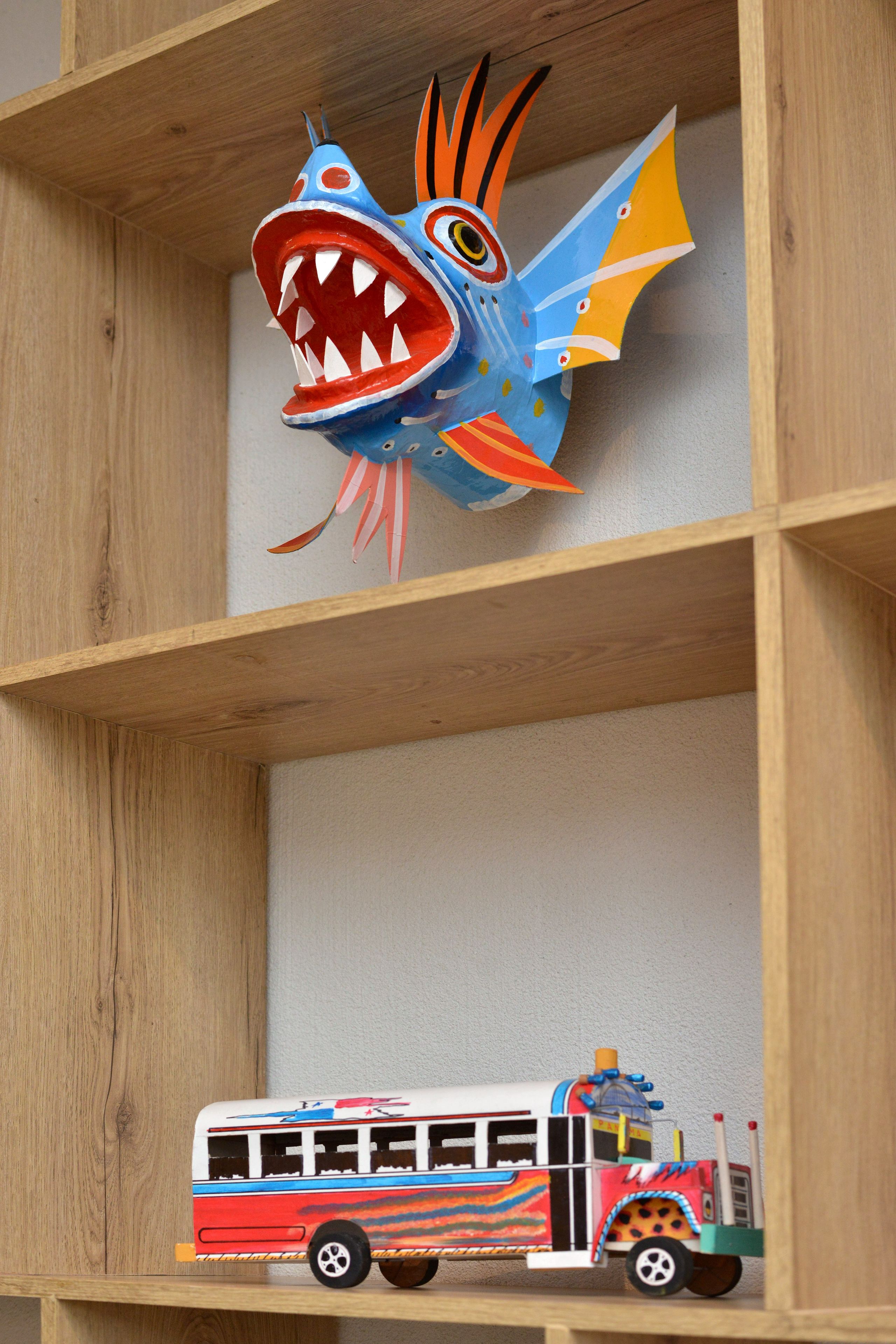 A shelf with a toy fish and a toy bus.