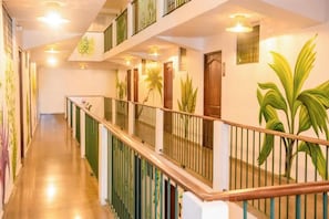 A hotel corridor with a wooden railing, doors, and wall-mounted plants. - Hotel Caracas - Casco Viejo (Panama City)