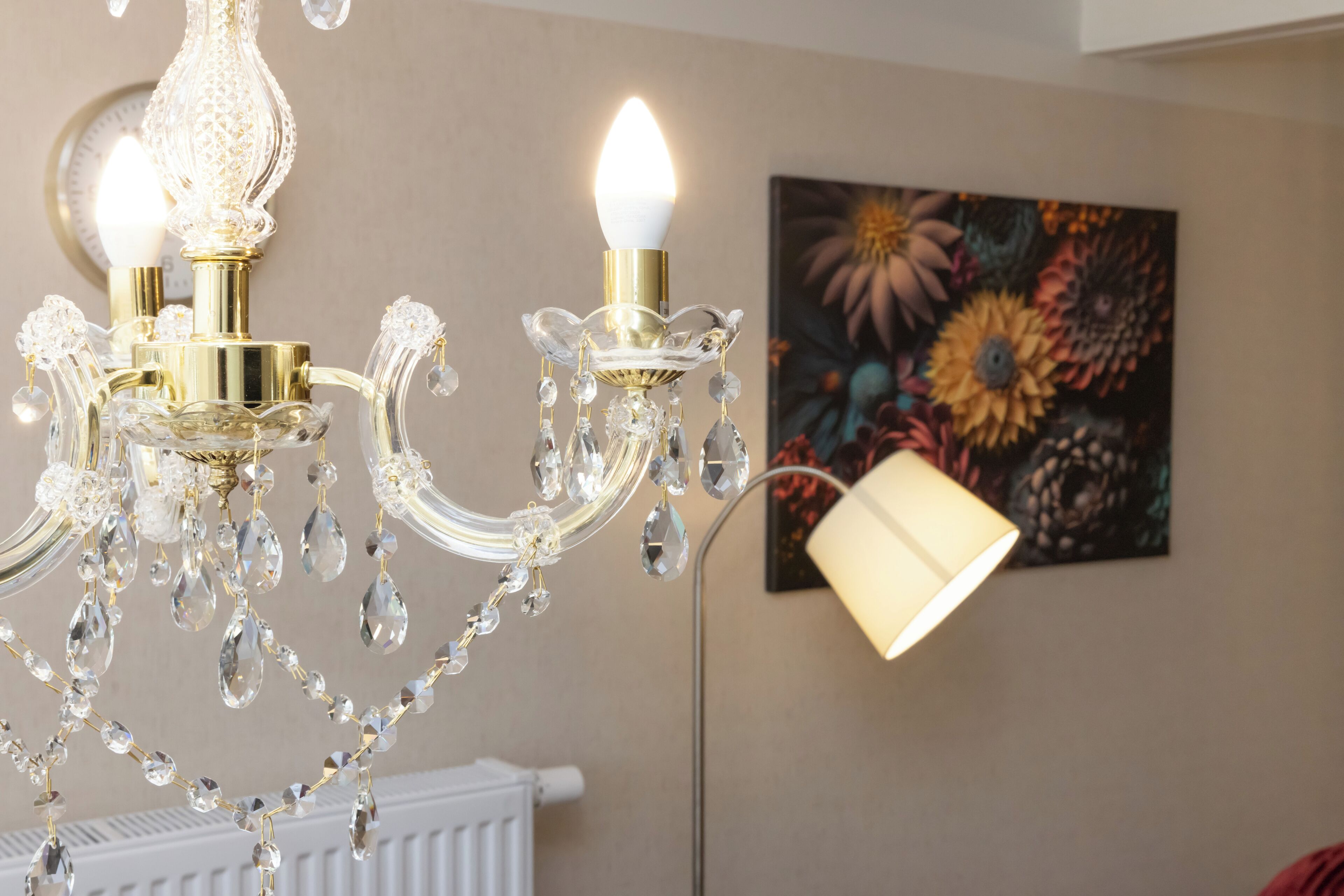 Un candelabro con detalles de cristal y una lámpara de pared.