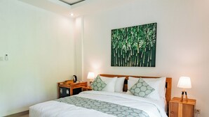 Un dormitorio con una cama grande, una mesita de noche, una lámpara de pared y un cuadro con árboles.