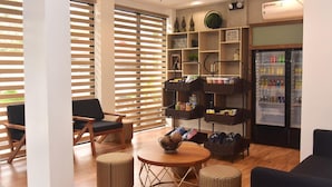A modern interior with a seating area, a beverage refrigerator, and storage shelves.