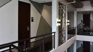 A modern interior with a geometric wall design, a staircase, and a railing.