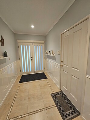 A hallway with a double door, a black doormat, and a patterned rug. - Dawesville Family Beach Getaway – Steps from the Sand & Estuary (Dawesville)