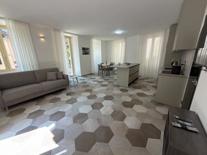 Ein modernes Apartment mit Wohnbereich, Essbereich und Küchenzeile.