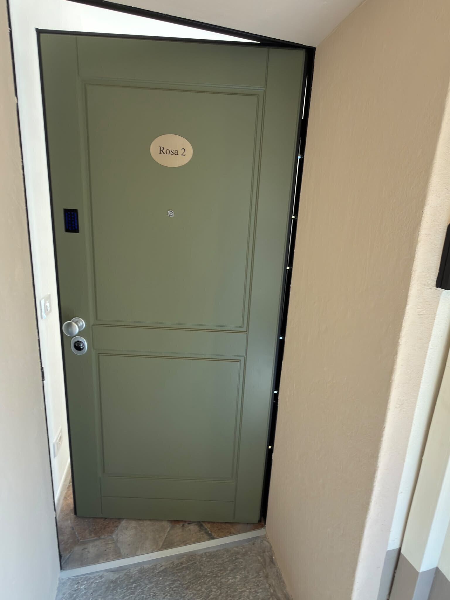 A closed door with a nameplate reading 'Rosa 2' and a keyhole.