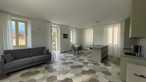 Een modern appartement met een woongedeelte, eethoek en kitchenette.
