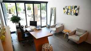 A modern office space with a desk, chairs, a large window, and a potted plant. - MyElla Marina Hotel (Bodrum)