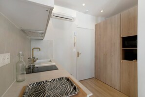 Una cocina moderna con horno empotrado, pileta y un mueble de madera.