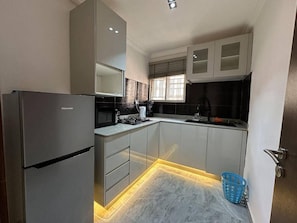 A modern kitchen with a built-in refrigerator, a stove, and a sink. - 2-Bedroom Luxury Apartment | Fast Wi-Fi | Smart TV | 24/7 Power & Security (Lagos)