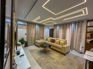 A modern living room with a sofa, a coffee table, and curtains. - 2-Bedroom Luxury Apartment | Fast Wi-Fi | Smart TV | 24/7 Power & Security (Lagos)