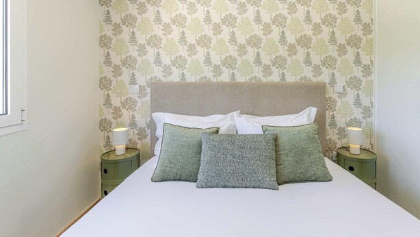 A bedroom with a bed, two bedside tables, and a wall with a tree pattern. - Olival Dream House - Boutique House w/ Pool (Pedorido)