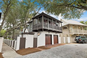 Ein zweistöckiges Haus mit Balkon, Garage und Auffahrt.
