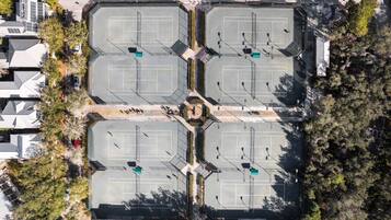 An aerial view of a parking lot with multiple parking spaces and a central pedestrian area.