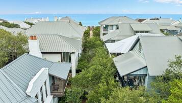 A residential area with houses featuring gabled roofs and a clear view of the ocean.