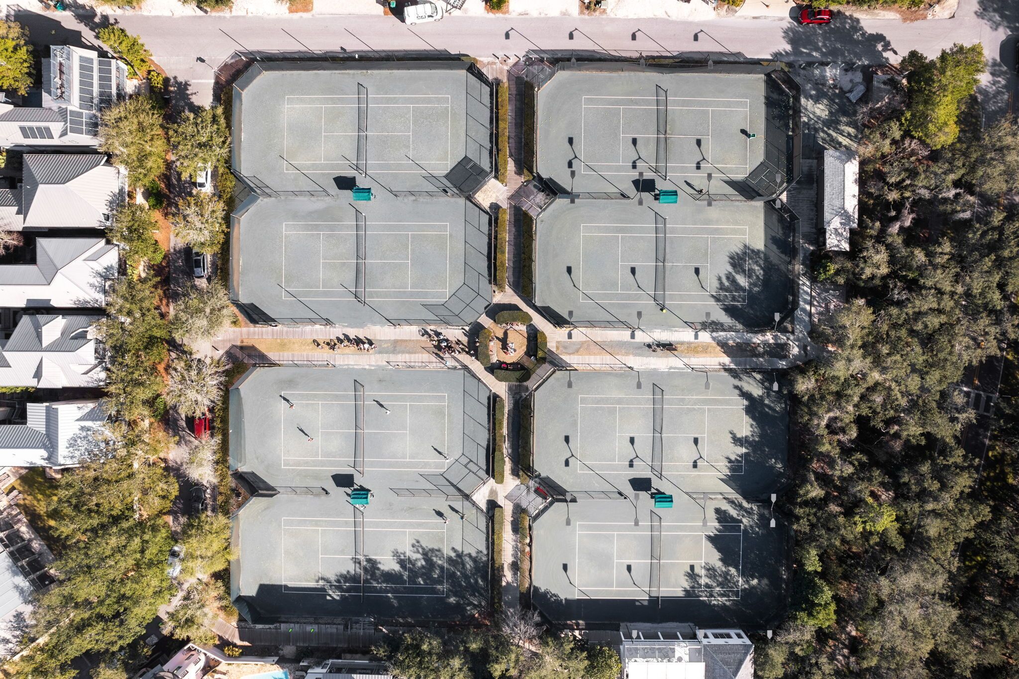 An aerial view of a parking lot with multiple parking spaces and a central pedestrian area.