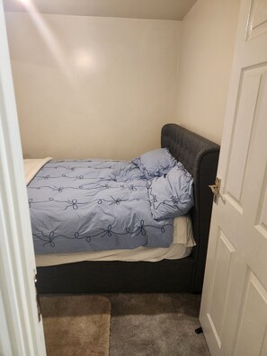 A small, single-bed room with a dark headboard and a light-colored wall. - 69 swan lane (Coventry)