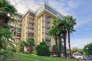 A multi-story residential building with balconies, surrounded by palm trees and a well-maintained lawn. - "BlueVille21" Apartment with Lake View, Shared Pool, and Wi-Fi (Euroville)