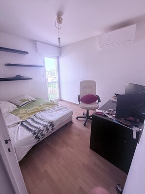 A bedroom with a bed, a desk, a chair, and a window. - Large family home with spacious, landscaped terraces, 100 meters from the beach (Mauguio)