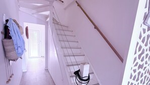 A narrow hallway with a staircase leading to a door at the end. - Large family home with spacious, landscaped terraces, 100 meters from the beach (Mauguio)