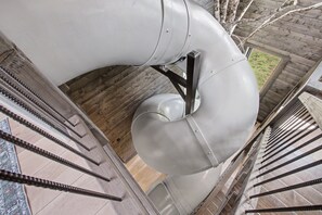 A spiral staircase with metal railings and a grey pipe structure. - Lazy River, Pool, Theater, Arcade, Golf Sim, Views (Sevierville)