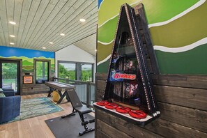 A room with a pool table, exercise equipment, and a wall-mounted game. - Lazy River, Pool, Theater, Arcade, Golf Sim, Views (Sevierville)